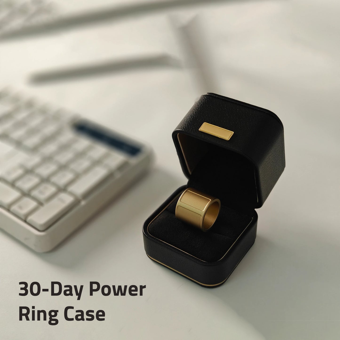 Gold ring in a black power ring case on a desk with a keyboard in the background