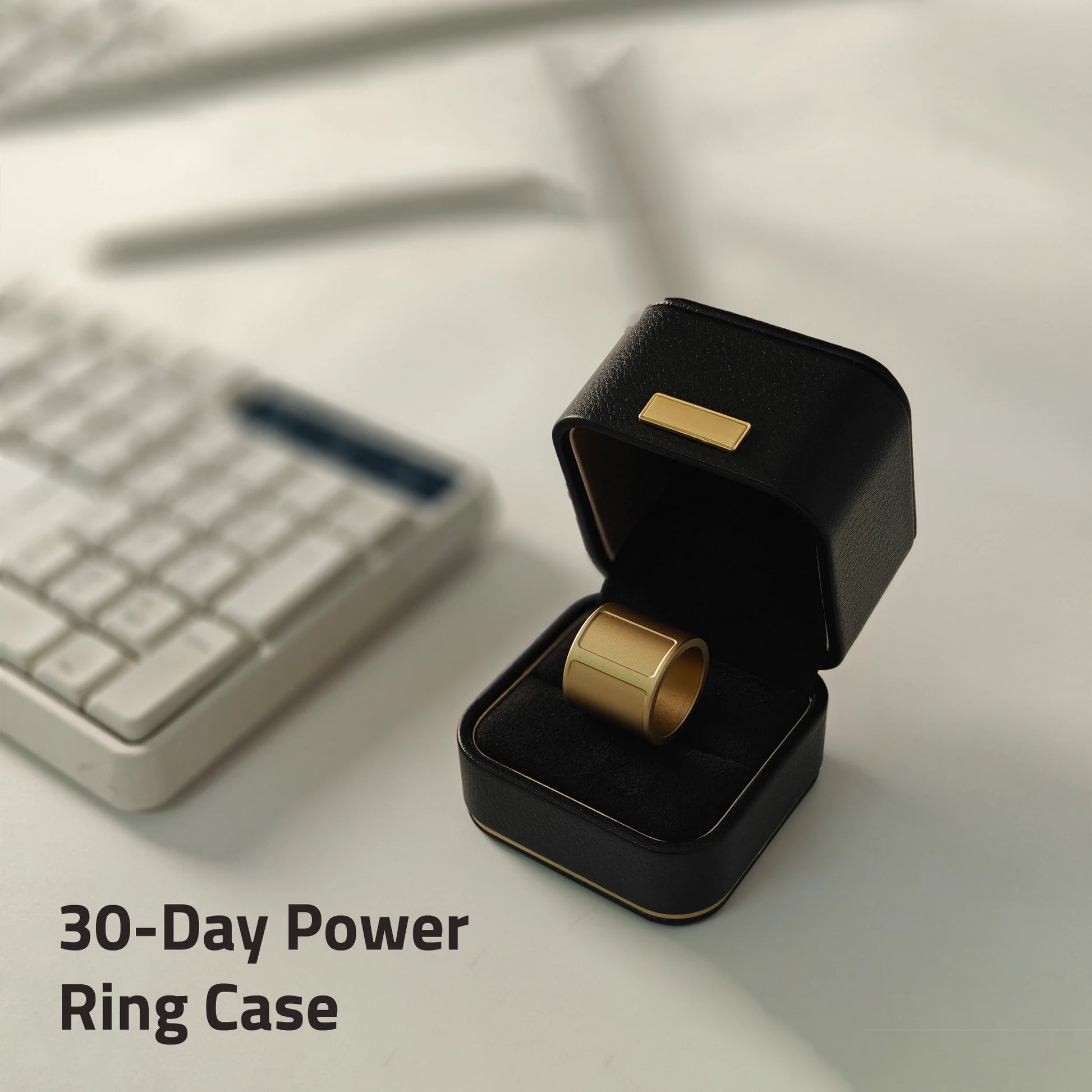 Gold ring in a black power ring case on a desk with a keyboard in the background